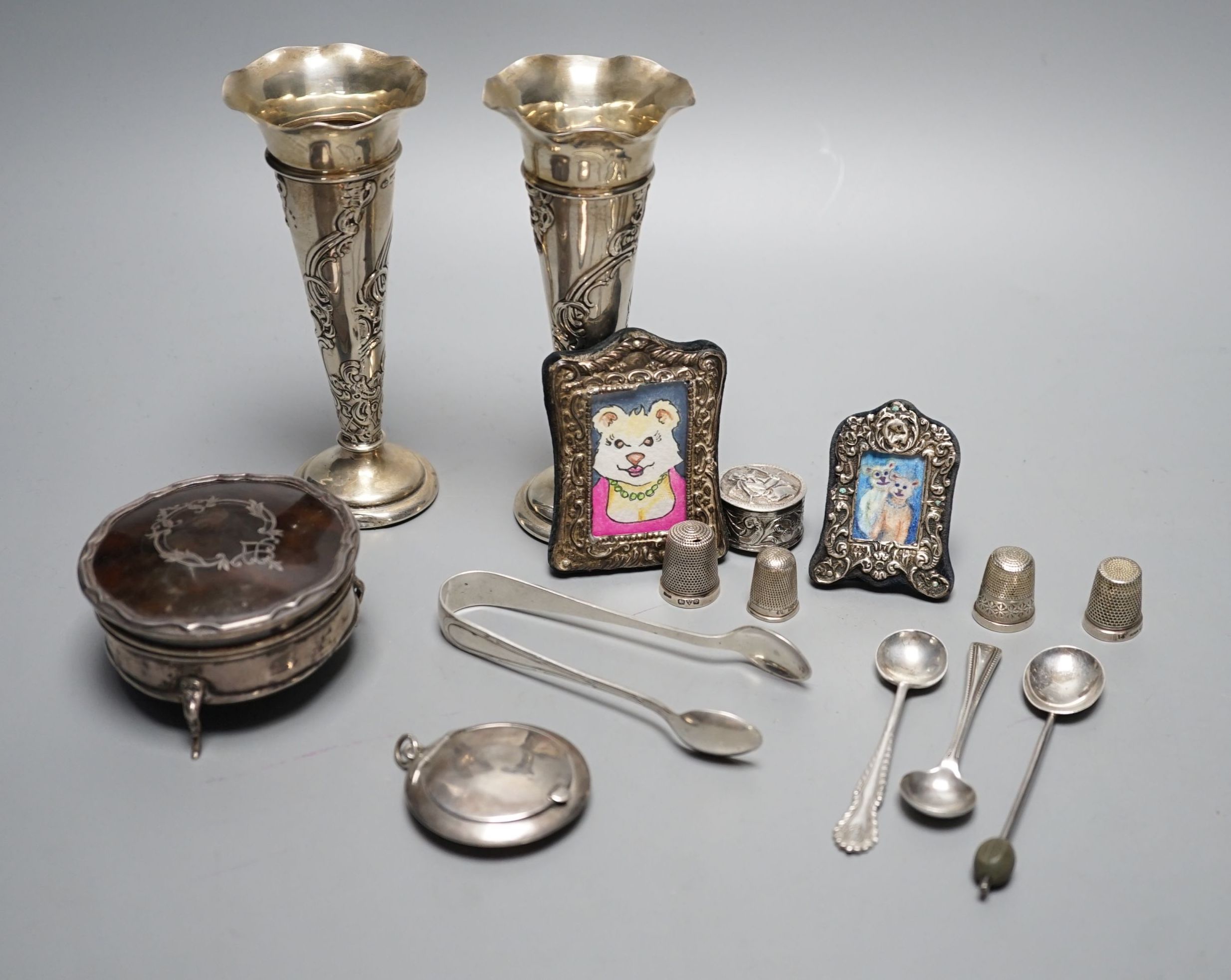 Mixed collectable silver including a pair of silver posy vases by William Comyns, 13.6cm, a George V silver and tortoiseshell trinket box, two small silver mounted photograph frames, four silver thimbles, compact, pill b